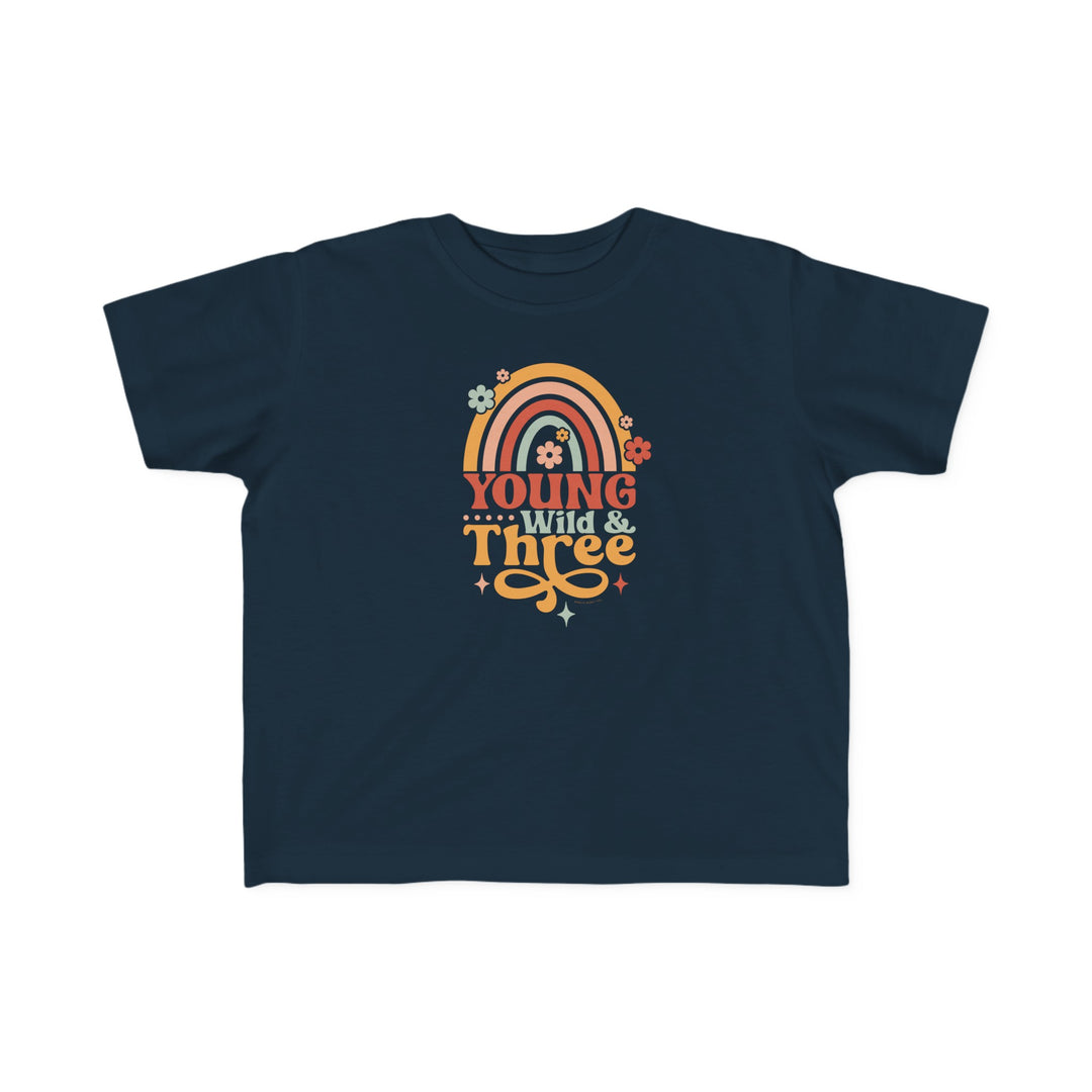 Young Wild and Three Toddler Tee featuring a blue shirt with a rainbow, flowers, and text. Ideal for sensitive skin, made of 100% combed ringspun cotton, light fabric, tear-away label, and a classic fit.