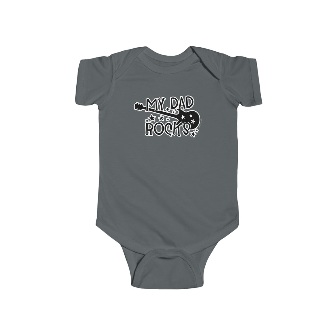 A grey baby bodysuit featuring a guitar and text, ideal for infants. Made of 100% cotton, light fabric with ribbed knit bindings for durability. Plastic snaps for easy changing access. Title: My Dad Rocks Onesie.
