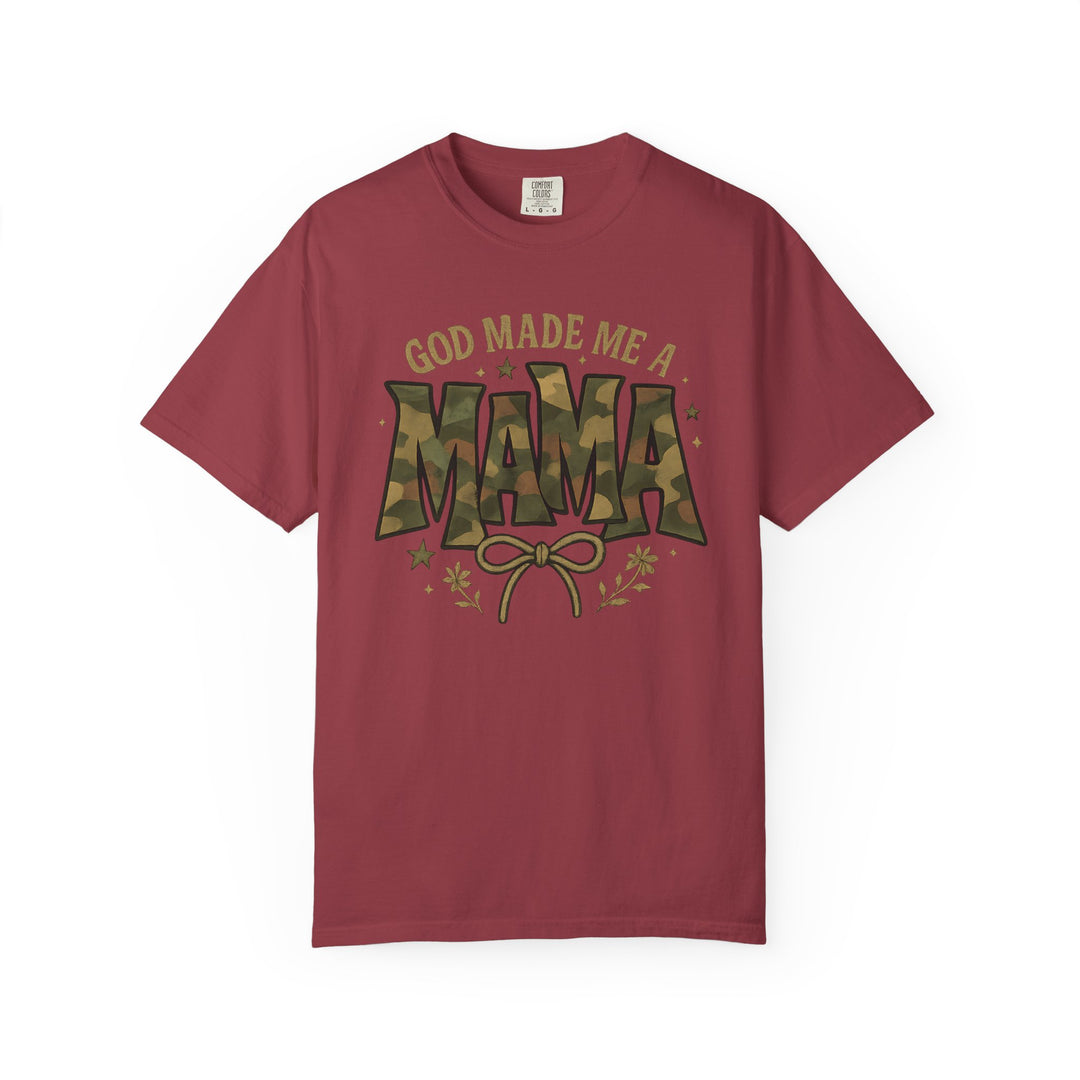 God Made Me a Mama Tee with camo text and floral accents on a reddish crew-neck, offering comfort and durability with its relaxed fit and quality cotton.