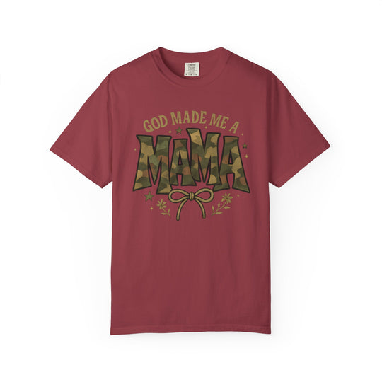 God Made Me a Mama Tee with camo text and floral accents on a reddish crew-neck, offering comfort and durability with its relaxed fit and quality cotton.