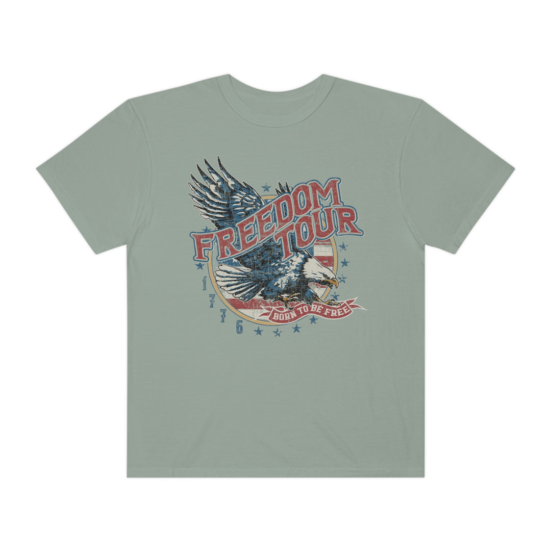 A relaxed fit Freedom Tour Tee, featuring a graphic design with a bird and text on soft ring-spun cotton. Garment-dyed for coziness, with double-needle stitching for durability. From Worlds Worst Tees.