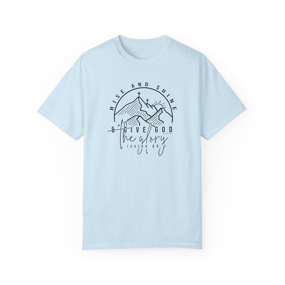 A light blue Rise and Shine Tee with a graphic design featuring a cross and mountains. Made of 100% ring-spun cotton, medium weight, and relaxed fit for everyday comfort.