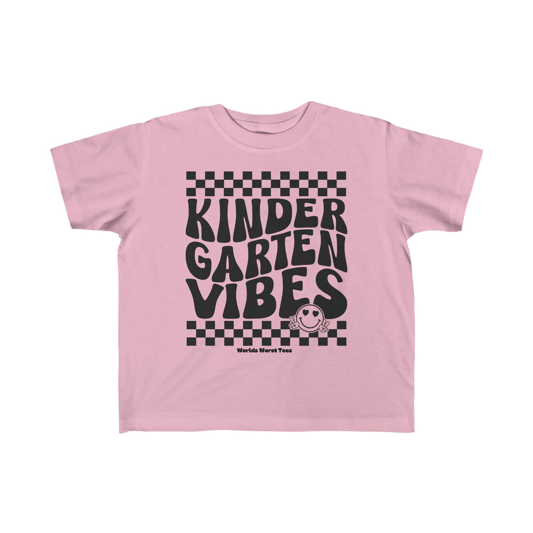 A Kindergarten Vibes Toddler Tee featuring black text on a pink shirt. Made of 100% combed ringspun cotton, light fabric, and a tear-away label. Ideal for sensitive skin, with a classic fit for toddlers.