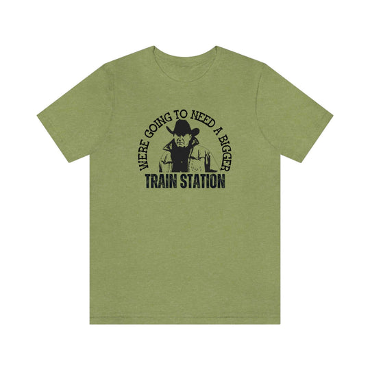 A premium fitted men’s tee, We're Going to Need a Bigger Train Station, in green with a cowboy design. Comfy, light, ribbed knit collar, 100% cotton. Ideal for workouts or daily wear.