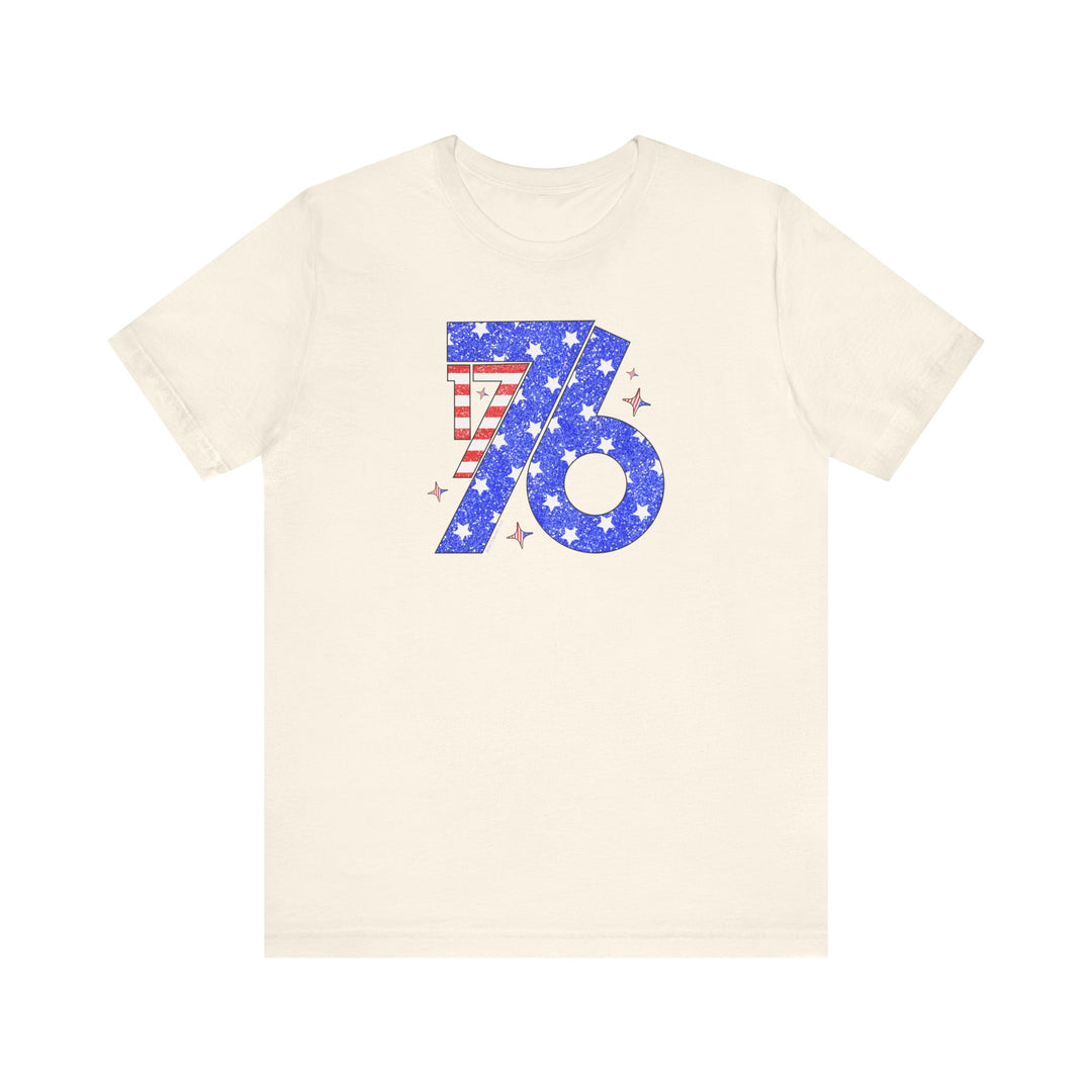 A white 1776 Tee featuring a blue and red design with numbers, stars, and stripes. Unisex jersey tee with ribbed knit collars, taping on shoulders, and tear away label. 100% Airlume combed and ringspun cotton.