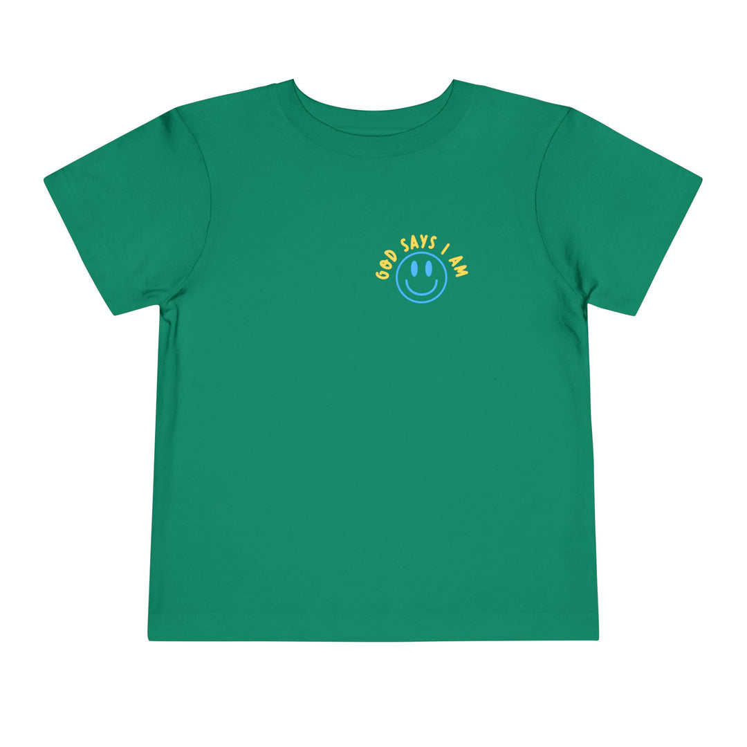 I AM Toddler Tee featuring a blue smiley-face graphic and GOD SAYS I AM. text on a green background, made from soft cotton for comfort.