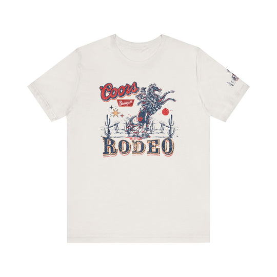 A white Coors Rodeo Tee with a cowboy graphic design on soft cotton. Unisex jersey tee with ribbed knit collar, taping on shoulders, and tear-away label. Retail fit, 100% Airlume combed cotton, 4.2 oz/yd².