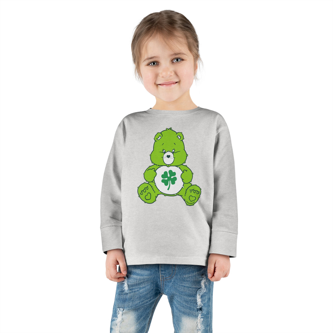 A custom Lucky Bear Toddler Long Sleeve Tee featuring a green bear design on a child. Made from 100% combed ringspun cotton for durability and comfort. Ideal for the youngest trendsetters.