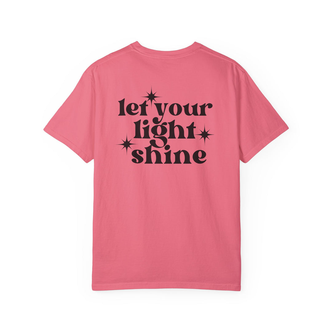 Let Your Light Shine Tee: Pink shirt with black text, featuring a star design. 100% ring-spun cotton, garment-dyed for coziness. Medium weight, relaxed fit, durable double-needle stitching. No side-seams for tubular shape.