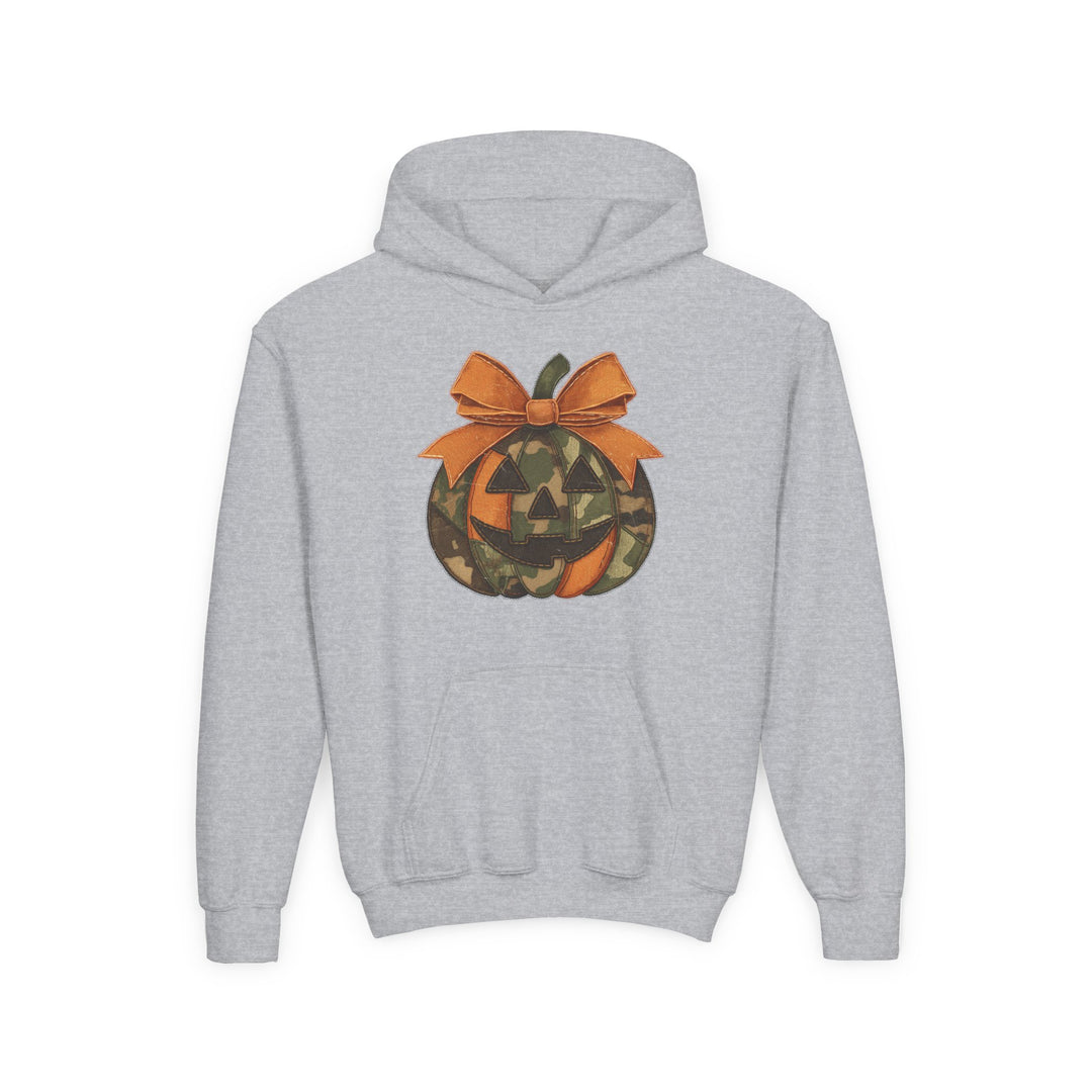 Jackie O Youth Hoodie features a light-gray pullover with a kangaroo pocket and a jack-o’-lantern graphic with orange and camouflage segments, topped with a bow.