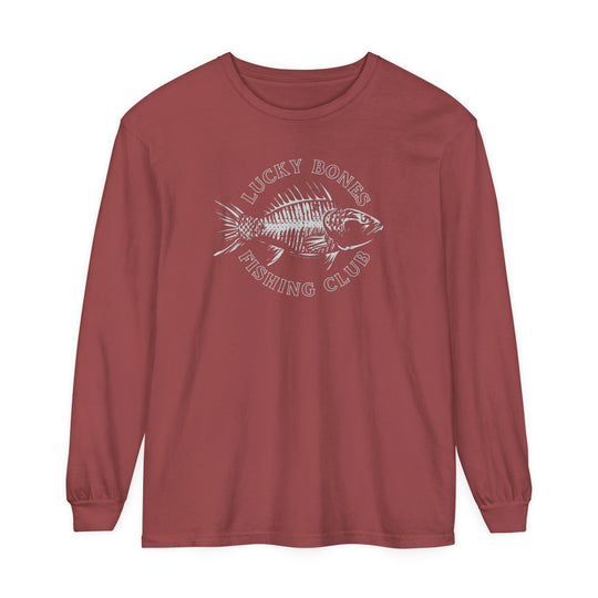 A Lucky Bones Fishing Club Long Sleeve Tee featuring a fish skeleton design on red fabric. Made of 100% ring-spun cotton, garment-dyed, and offering a relaxed fit for comfort. Ideal for casual wear.