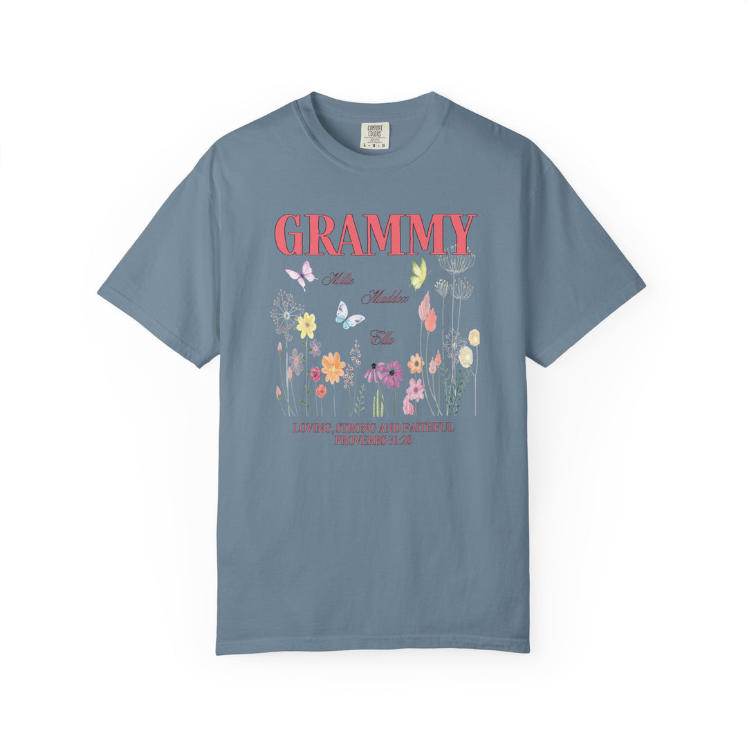 Close-up of the Grammy Tee, a blue t-shirt featuring intricate flower and butterfly designs, crafted from soft, durable, 100% ring-spun cotton.
