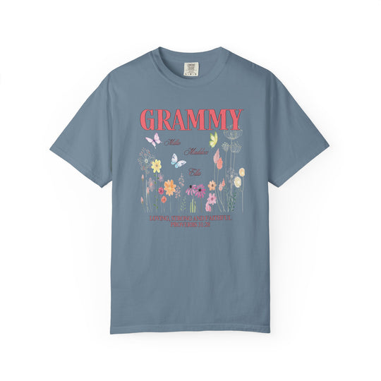 Close-up of the Grammy Tee, a blue t-shirt featuring intricate flower and butterfly designs, crafted from soft, durable, 100% ring-spun cotton.