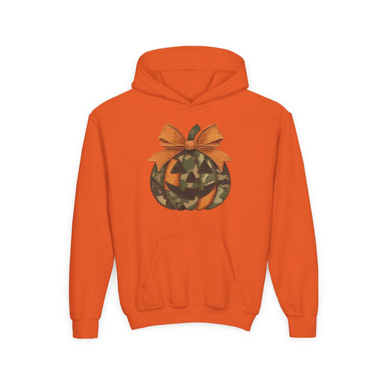 Jackie O Youth Hoodie features an orange pullover design with a camouflage jack-o’-lantern graphic and bow, offering a cozy, stylish fit with a kangaroo pocket.