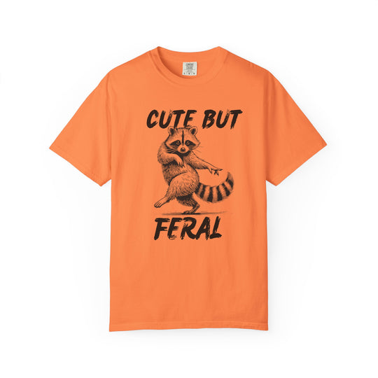 Orange T-shirt with Cute but Feral text and a sketch-style raccoon design, showcasing a casual and humorous style from Worlds Worst Tees.