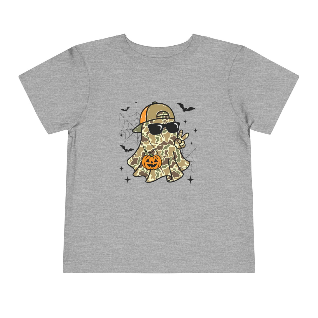 Candy Ghost Toddler Tee features a ghost in camouflage with a cap and sunglasses, holding a jack-o'-lantern bucket, surrounded by bats and webs.