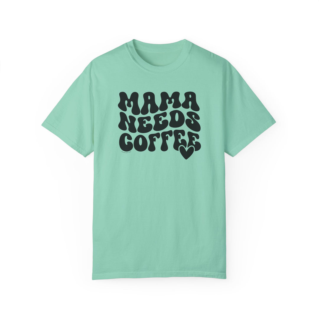 A Mama Needs Coffee Tee: Green shirt with black text, ring-spun cotton, medium weight, relaxed fit, durable double-needle stitching, seamless design for comfort.