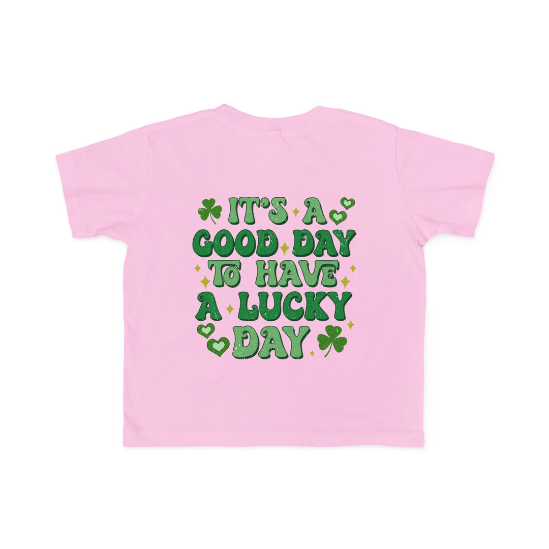 Good Day Lucky Day Toddler's Tee featuring green text and a clover on a pink background, designed for softness and durability, ideal for toddlers.