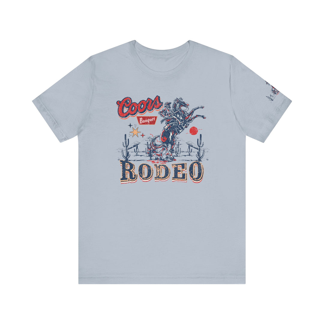 A classic Coors Rodeo Tee, featuring a graphic design of a cowboy on a horse. Unisex jersey tee with ribbed knit collars, taping on shoulders, and tear away label. Made of 100% Airlume combed cotton.