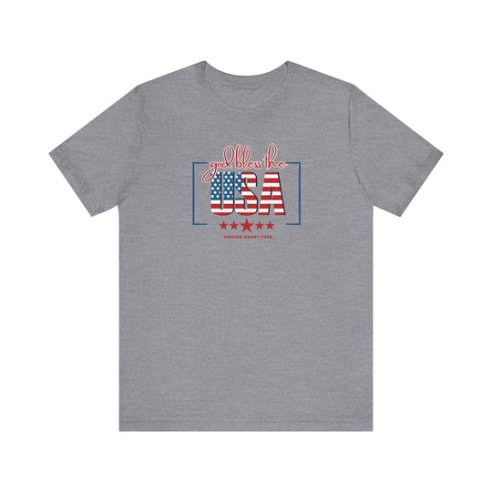 Unisex God Bless the USA Tee: Grey shirt with red, white, and blue text, stars and stripes design. Airlume combed cotton, ribbed collar, retail fit. Sizes XS-3XL. Ideal for patriotic style lovers.