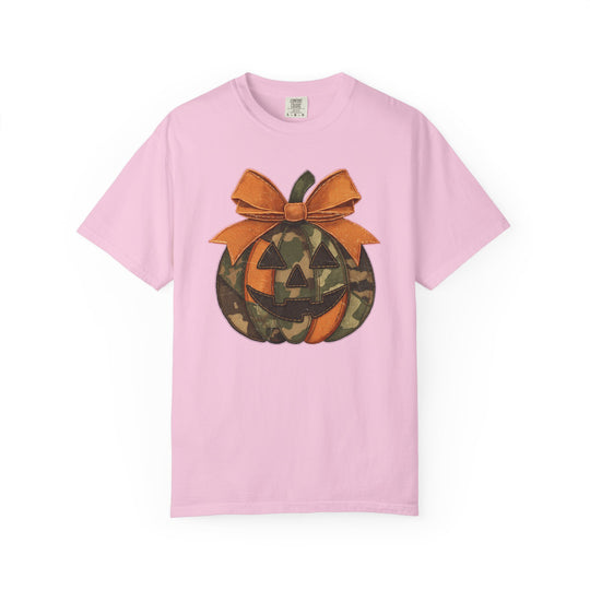 Jackie O Tee: Light pink crewneck T-shirt featuring a camo-patterned jack-o’-lantern graphic with triangular eyes, toothy smile, and large stitched orange bow.