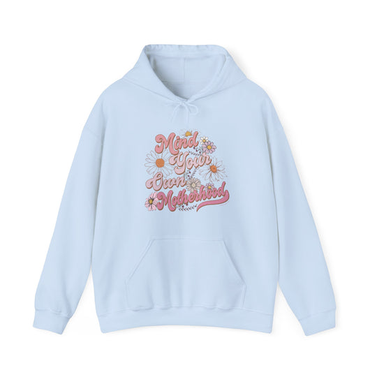 A light blue Mind Your Motherhood Hoodie with a pink and orange design. Unisex heavy blend hooded sweatshirt made of 50% cotton, 50% polyester, featuring a kangaroo pocket and color-matching drawstring.
