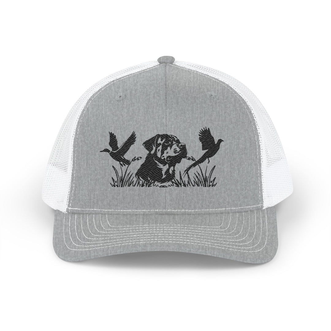 Bird Hunting Snapback Trucker Cap (Embroidery) featuring a hunting dog silhouette with flying waterfowl, perfect for casual wear with a breathable mesh back and adjustable fit.