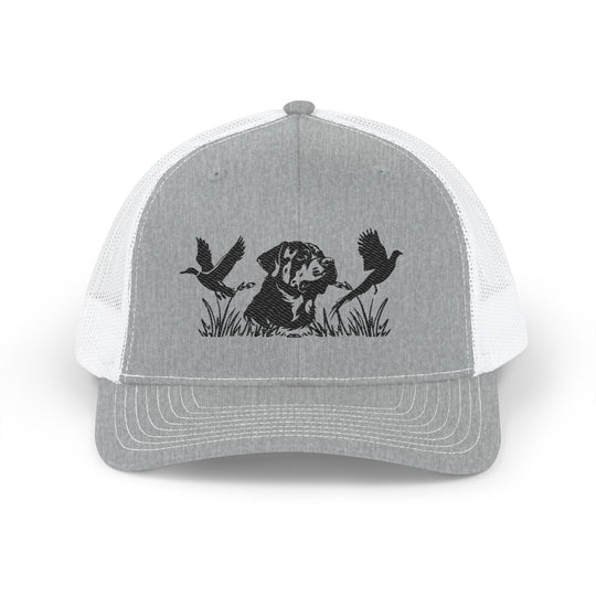 Bird Hunting Snapback Trucker Cap (Embroidery) featuring a hunting dog silhouette with flying waterfowl, perfect for casual wear with a breathable mesh back and adjustable fit.