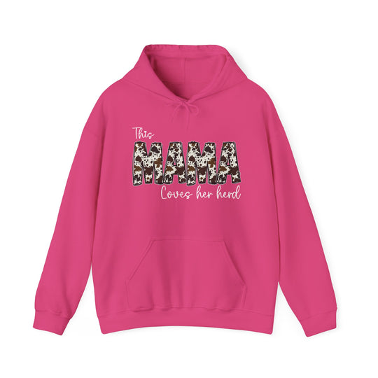 A pink unisex heavy blend Mama Herd Hoodie with cow print, kangaroo pocket, and drawstring hood. 50% cotton, 50% polyester, 8.0 oz/yd² fabric, tear-away label, classic fit. Sizes S-5XL.