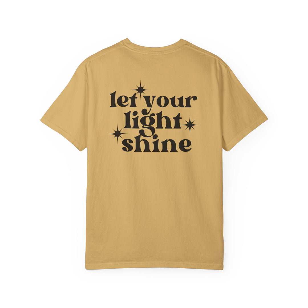 Let Your Light Shine Tee: Tan shirt with black text, 100% ring-spun cotton, garment-dyed for coziness, relaxed fit, double-needle stitching for durability, no side-seams for shape retention.