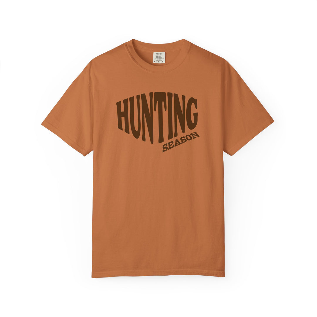 Burnt-orange Hunting Season Tee with dark-brown graphic text, short sleeves, relaxed fit, laid flat. Made of soft, durable, ring-spun cotton.