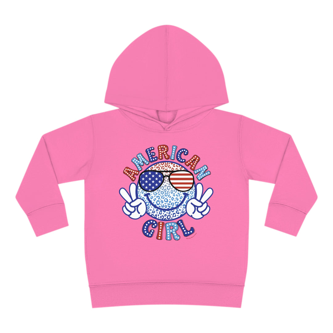 American Girl Toddler Hoodie featuring a pink hoodie with a smiley face and peace sign cartoon character. Designed for comfort with jersey-lined hood, cover-stitched details, and side seam pockets. Ideal for cozy playtime.
