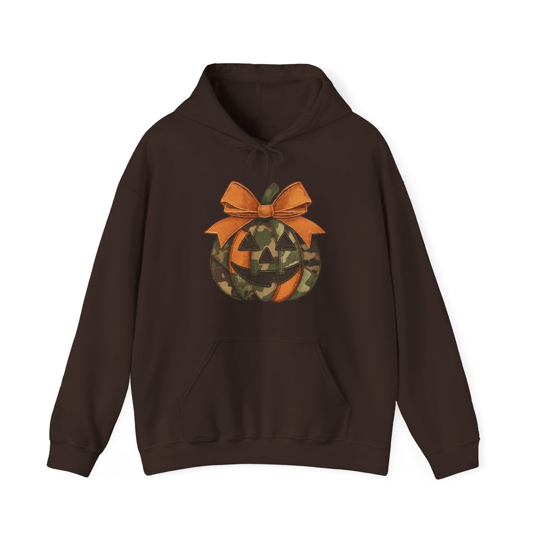 Copy of Jackie O Hoodie: Dark-brown pullover with kangaroo pocket and drawstring hood, featuring a camouflage jack-o’-lantern graphic topped with an orange bow.