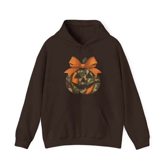 Copy of Jackie O Hoodie: Dark-brown pullover with kangaroo pocket and drawstring hood, featuring a camouflage jack-o’-lantern graphic topped with an orange bow.