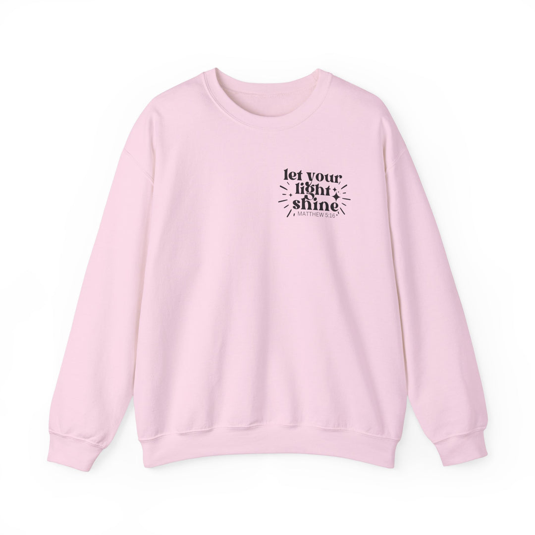 A unisex heavy blend crewneck sweatshirt, Let Your Light Shine Crew, in pink with black text. Made of 50% Cotton 50% Polyester, ribbed knit collar, no itchy side seams. Comfortable and stylish.