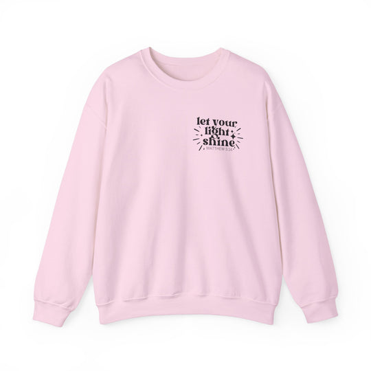 A unisex heavy blend crewneck sweatshirt, Let Your Light Shine Crew, in pink with black text. Made of 50% Cotton 50% Polyester, ribbed knit collar, no itchy side seams. Comfortable and stylish.