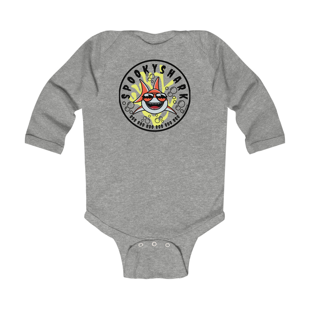 A durable Spooky Shark Long Sleeved Onesie for infants. Features smooth cotton fabric, ribbed bindings, and plastic snaps for easy changing. Classic fit with a cartoon shark design. From 'Worlds Worst Tees'.