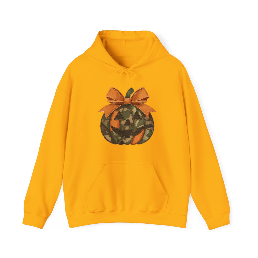 Mustard-yellow Copy of Jackie O Hoodie with kangaroo pocket, featuring a camo jack-o’-lantern graphic and orange bow, ideal for warmth and style.