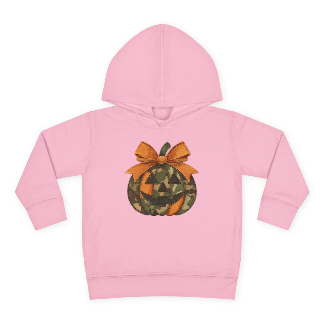 Light-pink Jackie O Toddler Hoodie with camouflage jack-o’-lantern design and orange bow, featuring a durable, cozy construction with side-seam pockets for toddlers.