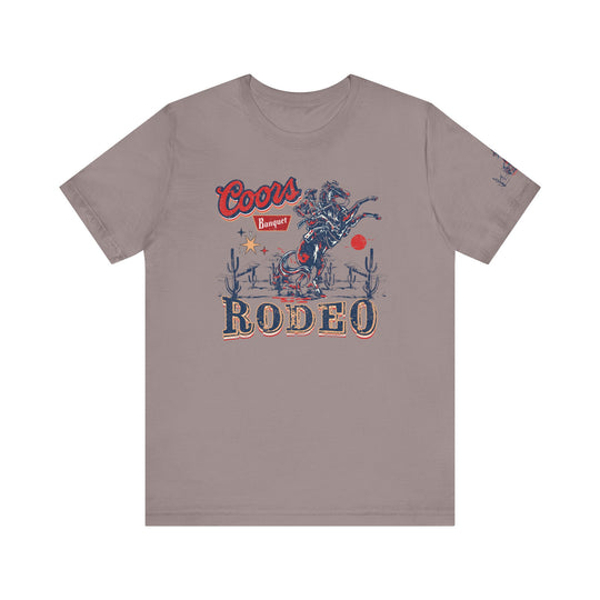 A Coors Rodeo Tee, a classic unisex jersey shirt with a graphic design of a cowboy. Made of 100% cotton, featuring ribbed knit collars and taping on shoulders for a better fit.