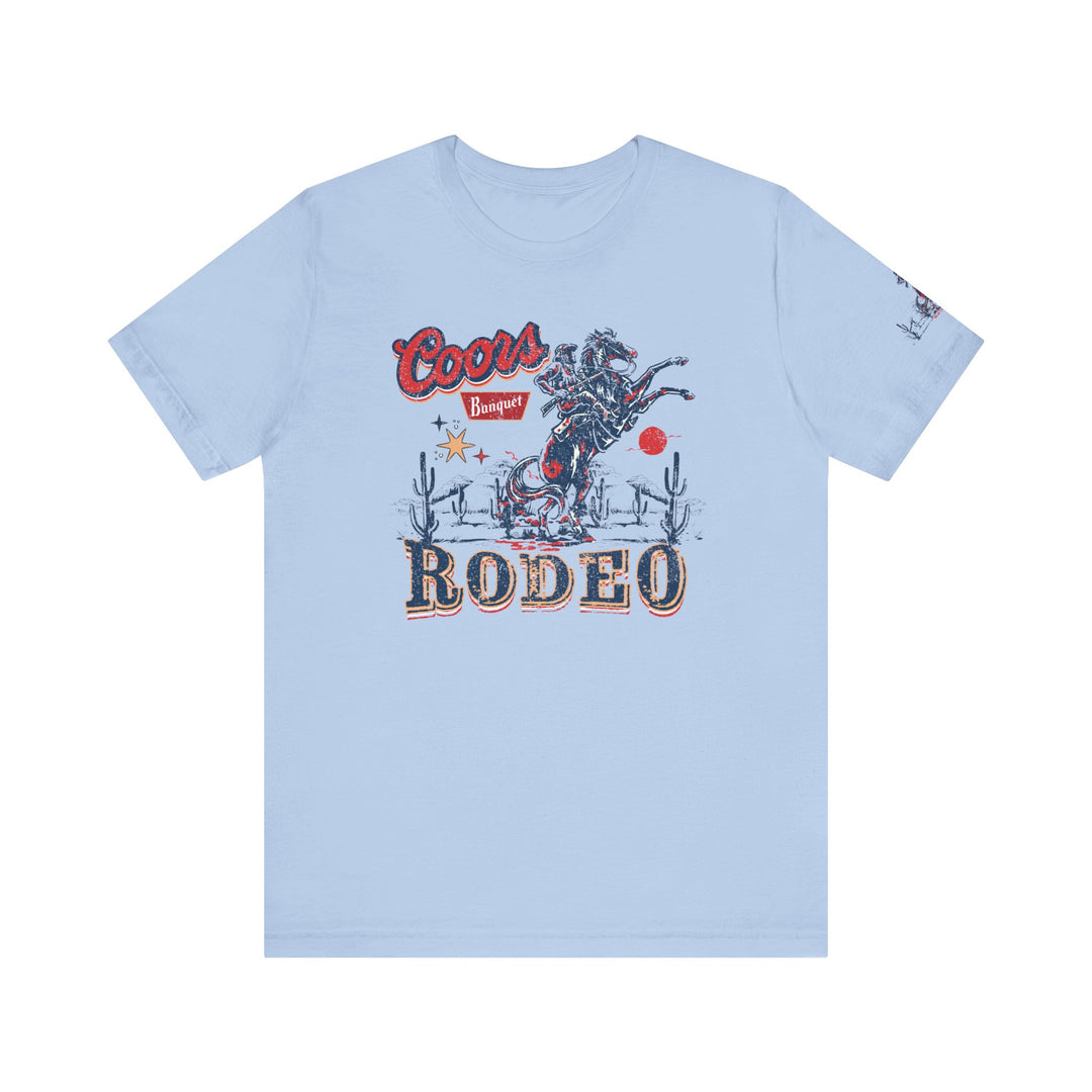 Coors Rodeo Tee: A blue t-shirt featuring a cowboy graphic on a horse. Unisex jersey tee with ribbed knit collar, 100% cotton, retail fit, tear away label. Sizes XS-3XL. World's Worst Tees.