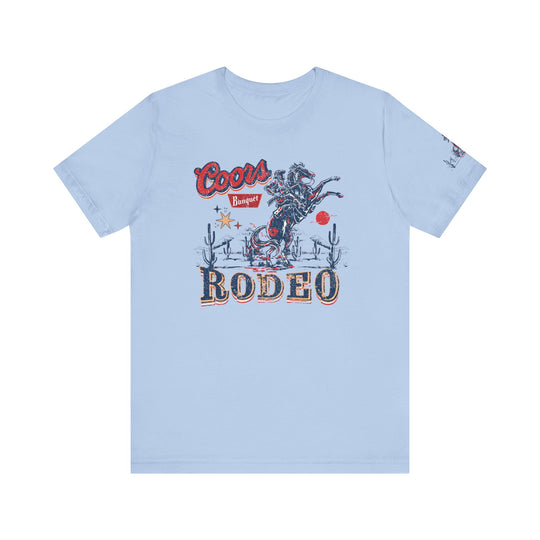 Coors Rodeo Tee: A blue t-shirt featuring a cowboy graphic on a horse. Unisex jersey tee with ribbed knit collar, 100% cotton, retail fit, tear away label. Sizes XS-3XL. World's Worst Tees.