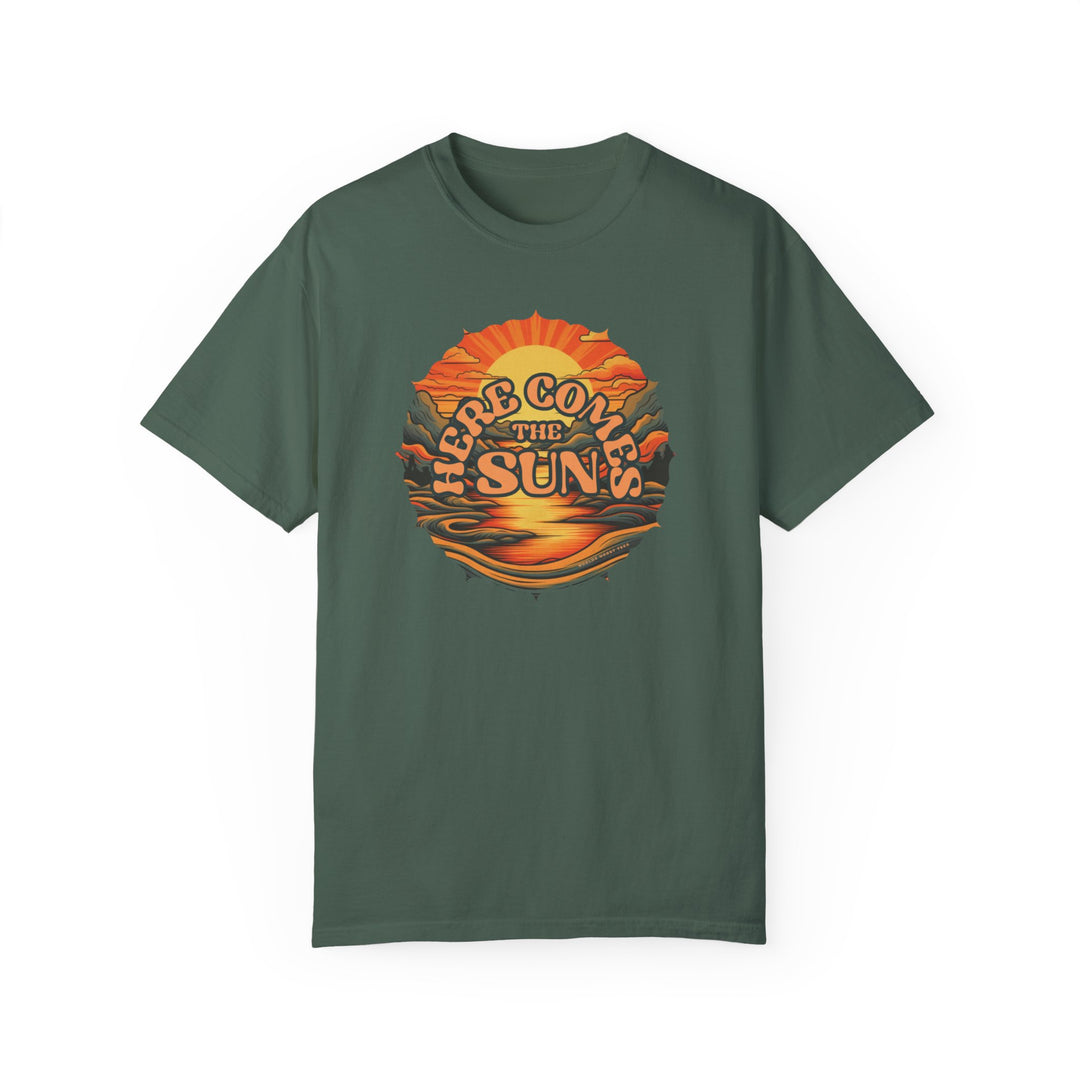 A relaxed fit Here Comes The Sun Tee, a green shirt with a graphic design of a sunset and mountains. Made of 100% ring-spun cotton, featuring a soft-washed, garment-dyed fabric for extra coziness. Double-needle stitching for durability.