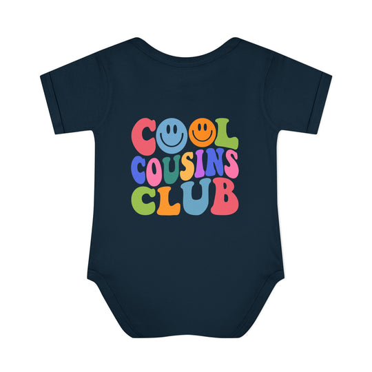 Baby wearing a Cool Cousins Club onesie with lap shoulders, designed for comfort with 100% ring-spun cotton, suitable for infants from newborn to 24 months.