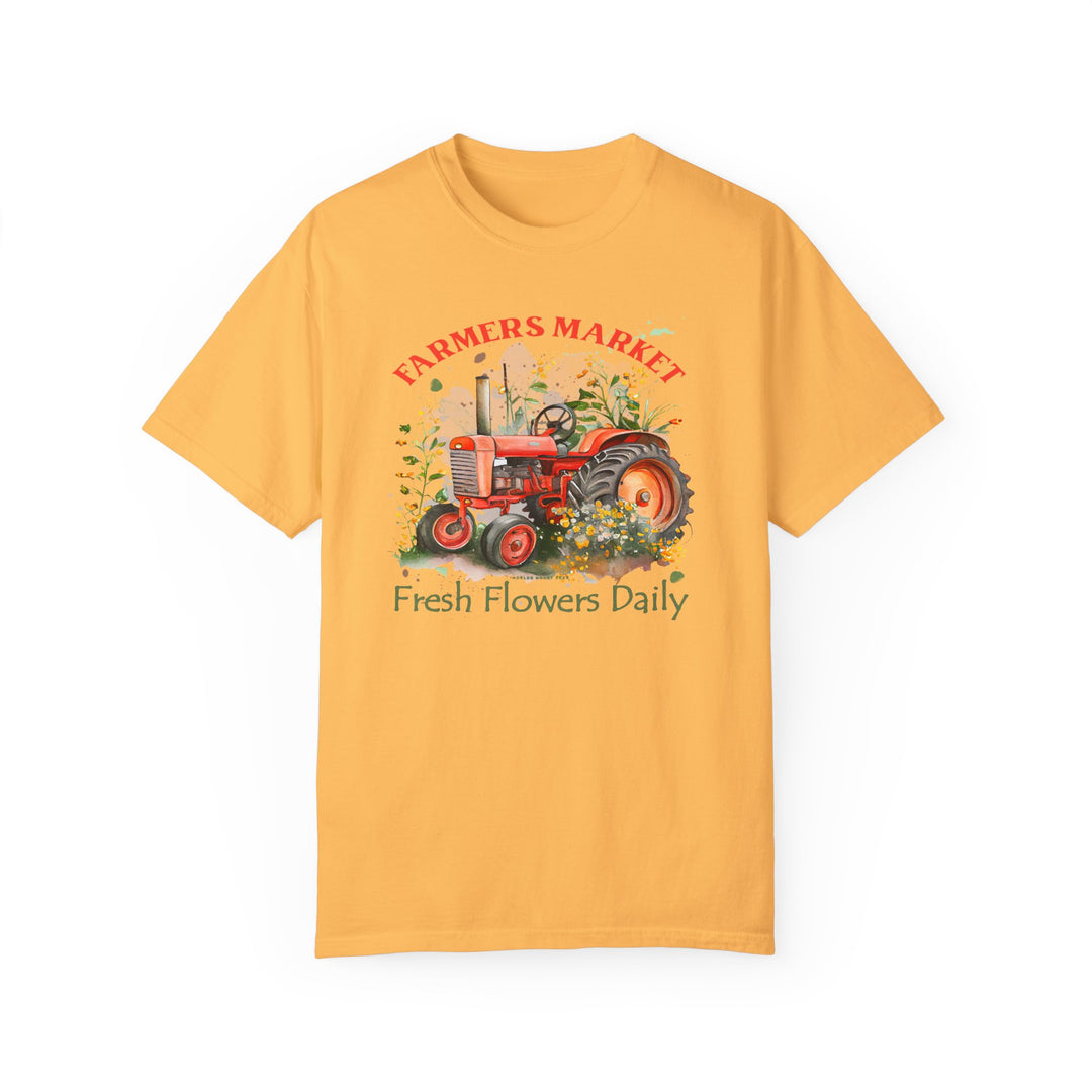 Alt text: Fresh Flowers Tee: A yellow shirt featuring a tractor and floral design, made of 100% ring-spun cotton with a relaxed fit and double-needle stitching for durability.