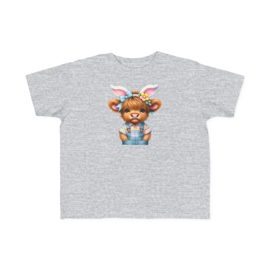 A grey toddler tee featuring a cartoon cow with bunny ears, ideal for sensitive skin. Made of 100% combed ringspun cotton, light fabric, classic fit, and tear-away label. Title: Easter Cow Toddler Tee.