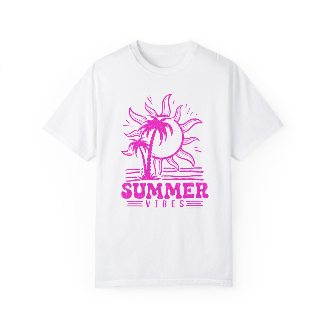 A Summer Vibes Tee featuring a white shirt with pink sun and palm tree graphics. Made of 100% ring-spun cotton, garment-dyed for extra coziness, with a relaxed fit and double-needle stitching for durability.