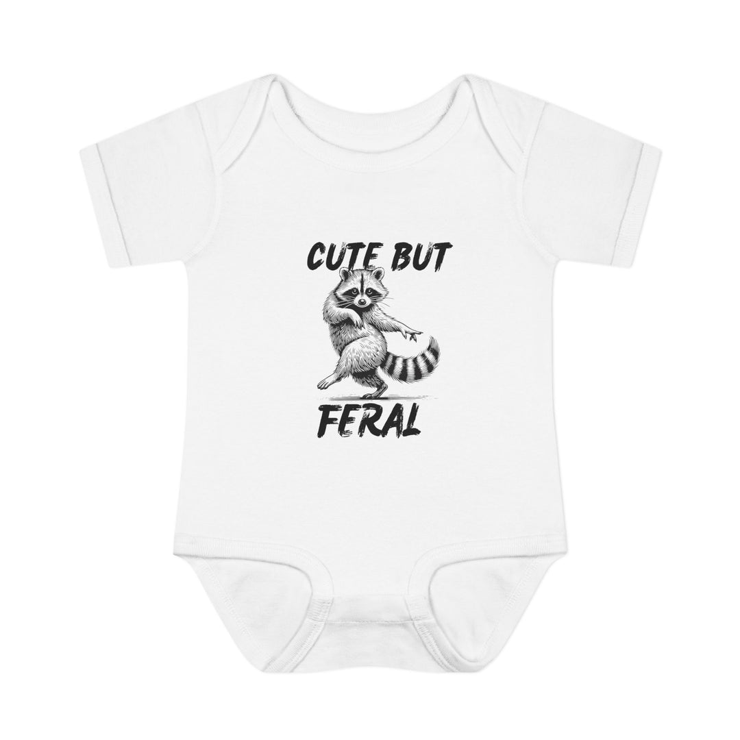 White baby onesie featuring a black-ink raccoon illustration with CUTE BUT FERAL slogan, highlighting its playful design and soft, comfortable fabric for infants.