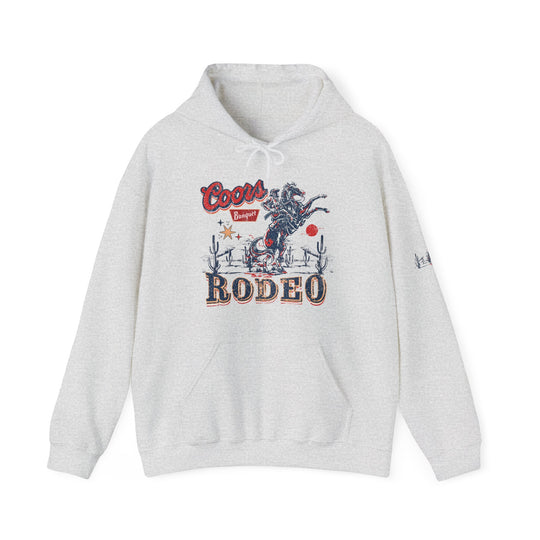 A Coors Rodeo Hoodie, a white sweatshirt with a graphic design, a logo close-up, and a kangaroo pocket. Unisex heavy blend, cotton-polyester fabric, no side seams, classic fit. Ideal for warmth and printing.