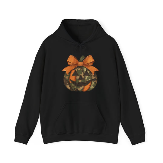 Black pullover hoodie with a graphic jack-o-lantern featuring orange and camouflage patches and a large bow, includes kangaroo pocket and drawstring hood.